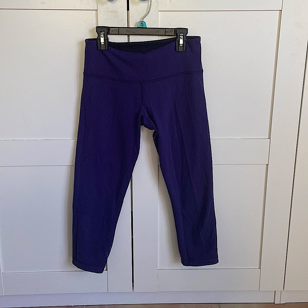Cropped Lululemon leggings that are reversible. One side black the other purple.